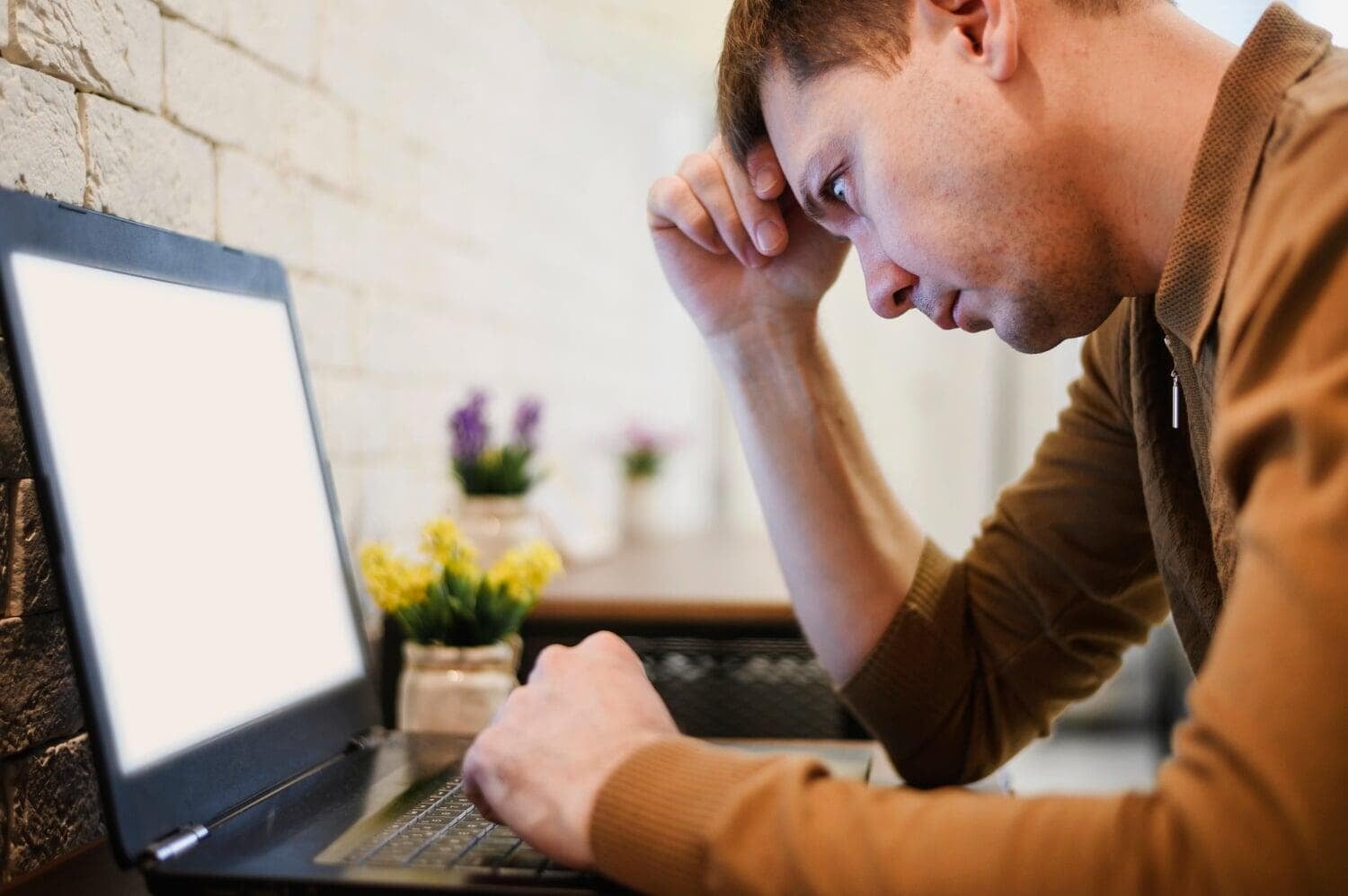 Homem se lamentando em frente a um notebook