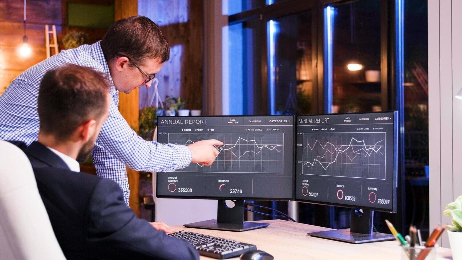 Homens analisando gráficos em monitores