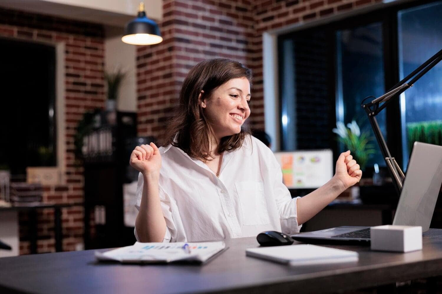 Mulher comemorando em frente a um notebook