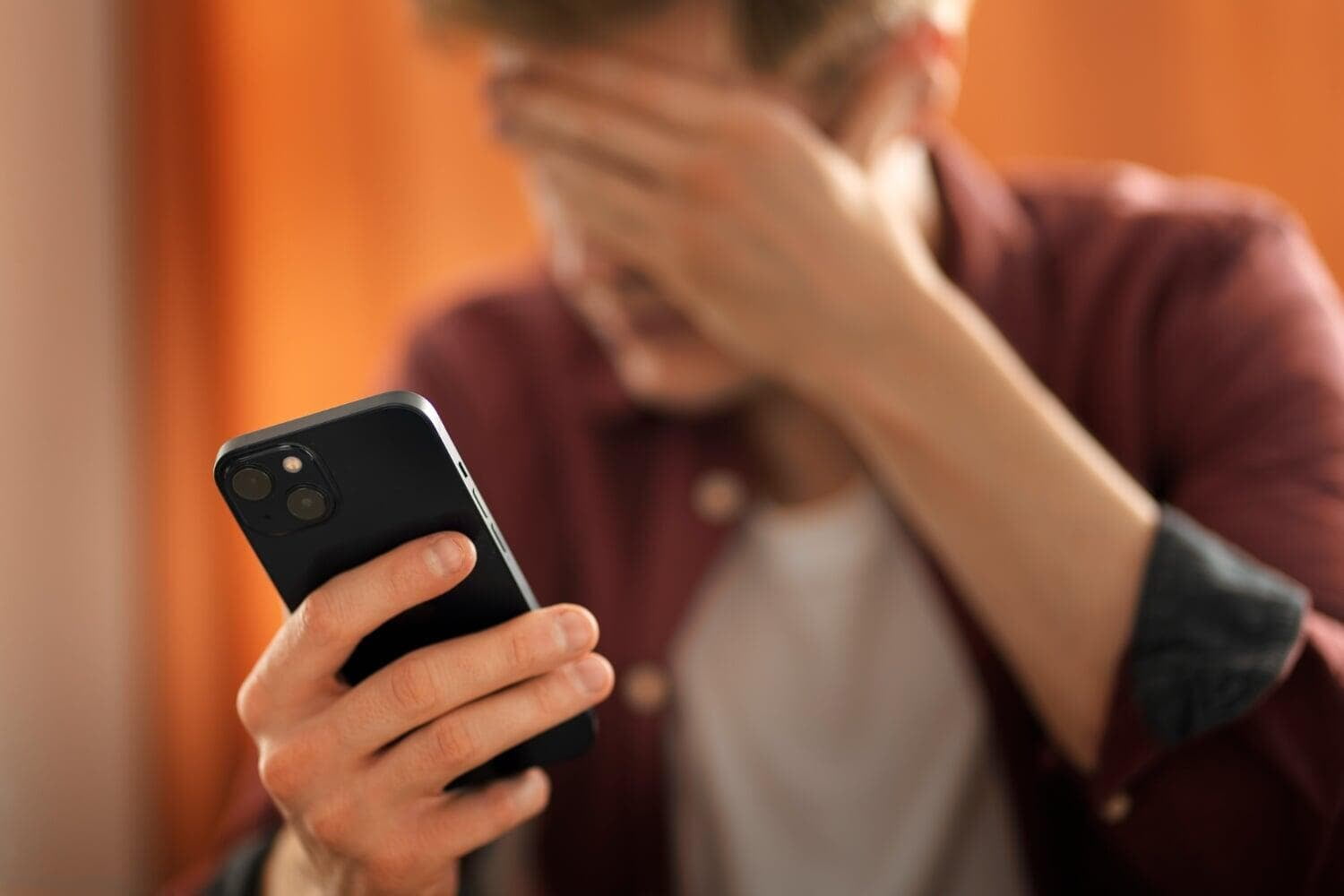 Homem lamentando segurando um celular