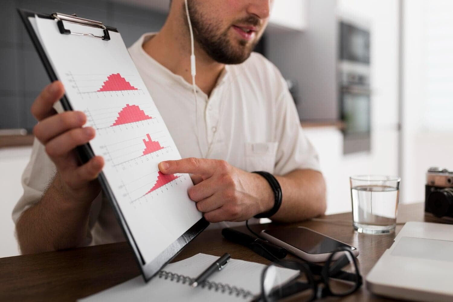 Homem em ambiente corporativo apontando para gráficos em um papel