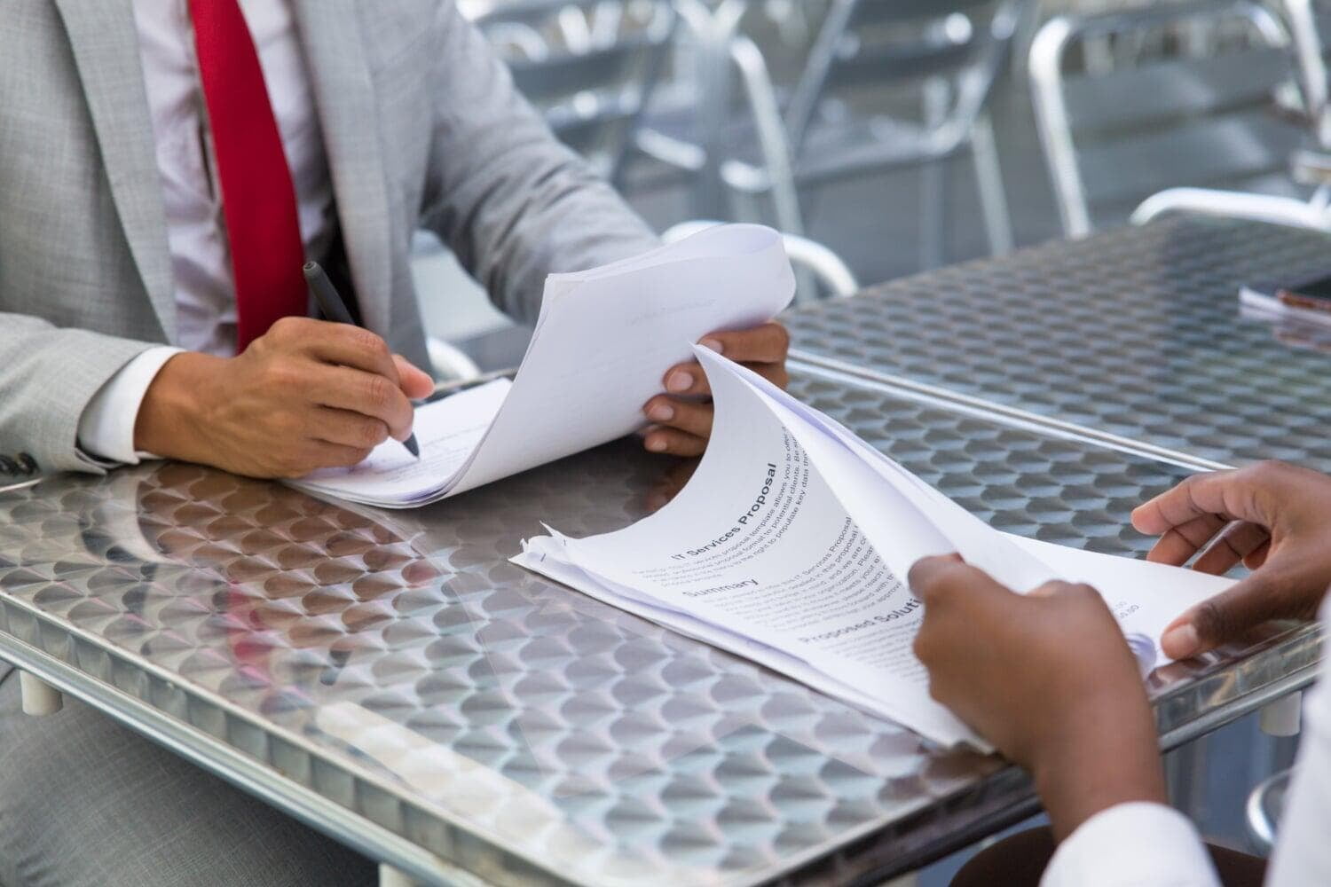 Pessoas assinando documentos em uma mesa