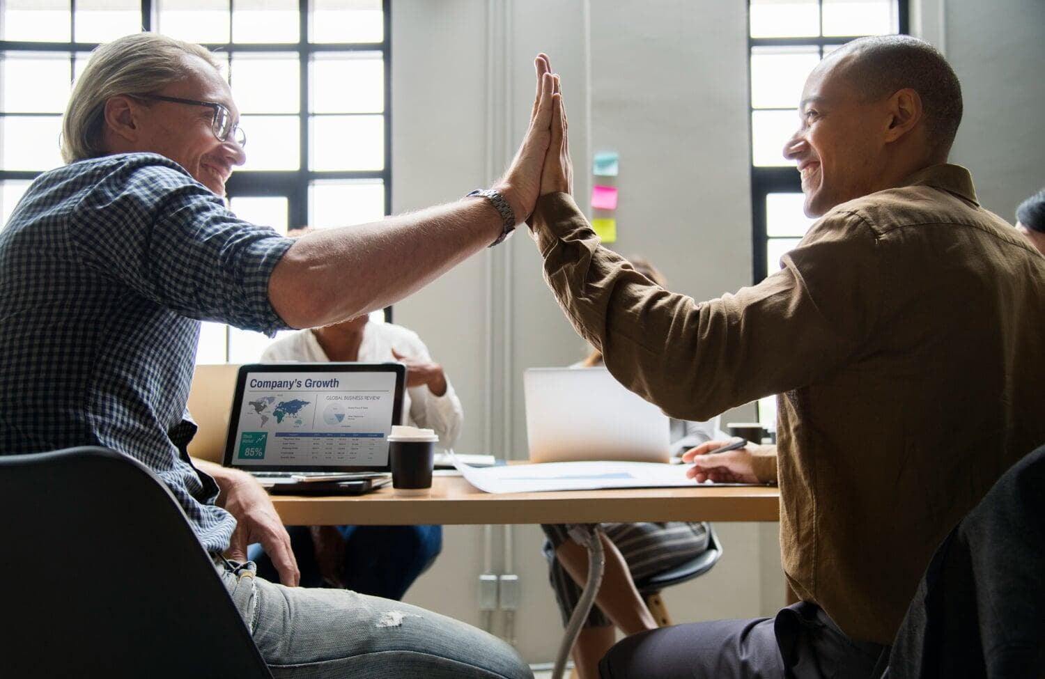 Dois homens em ambiente corporativo se cumprimentando